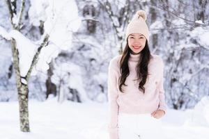 portret jonge mooie aziatische vrouw glimlach gelukkig reizen en genieten met sneeuw winterseizoen foto