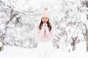 portret jonge mooie aziatische vrouw glimlach gelukkig reizen en genieten met sneeuw winterseizoen foto