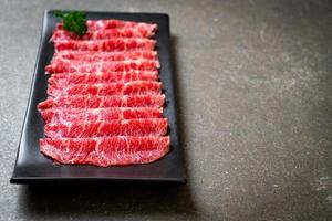 vers rundvlees rauw gesneden met gemarmerde textuur geserveerd voor sukiyaki en shabu of yakiniku foto