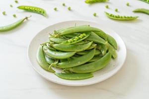 verse zoete groene erwten op witte plaat foto