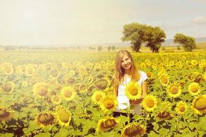 lachende jonge vrouw in veld zonnebloemen, landbouwtijd op het platteland foto