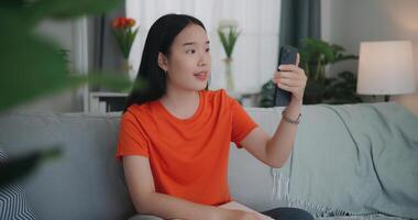 jong Aziatisch vrouw video telefoontje met vriend Aan mobiel telefoon foto