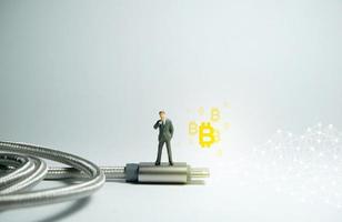 zakenman staande op een usb type c. bitcoin cryptocurrency-concept. foto