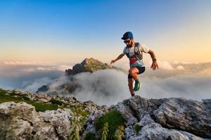 man ultramarathon loper in de bergen die hij traint bij zonsondergang