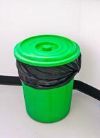 groen bak met zwart vuilnis zak en deksel voor sanitair foto
