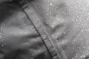 natte regenjas van gladde en strakke grijze waterdichte stof foto