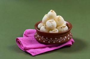 indisch snoepje - rasgulla, beroemd bengaals snoepje in kleikom met servet foto