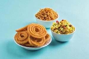 Indiase snack chakli, chakali of murukku en besan gram meel sev en chivada of chiwada op blauwe achtergrond. diwali eten foto