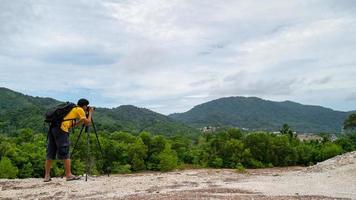 professionele mannelijke fotograaf op hoge berg maakt een foto