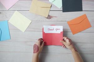 kind hand met bedankbrief op tafel foto