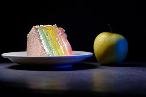 groene appel en een bakkerijcake op zwarte achtergrond foto