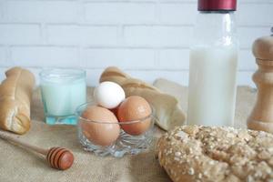 eieren in een kom, volkoren brood en melk op tafel foto