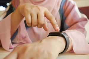 vrouwenhand die tijd op slim horloge controleren,