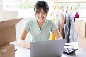 jonge aziatische vrouw die een online verkoopcarrière aan huis begint foto