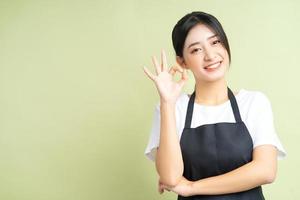 Aziatische serveerster poseren ok handen ok