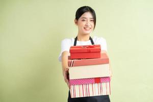 Aziatische vrouwelijke serveerster met geschenkdoos