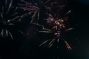 Aan een zwart achtergrond bokeh van explosies van kleurrijk vuurwerk. foto