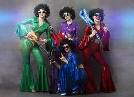 meisjes in kleurrijk glimmend kostuums en Afrikaanse pruiken met gitaren. wijnoogst muziek- disco band voor Dames. foto