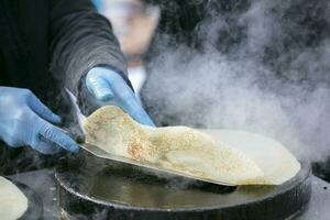 gieten de pannenkoek beslag in de koekepan. bereiden pannekoeken. foto