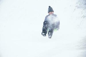 kind rodelen cheesecake.sleeën uit een sneeuw glijbaan foto