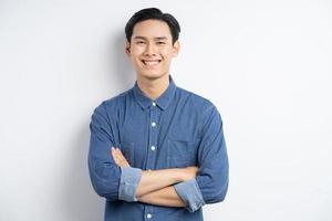 foto van een Aziatische man die met zijn armen over elkaar staat en lacht op een witte achtergrond white