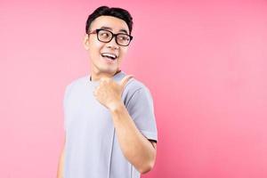 portret van aziatische man die zich voordeed op roze achtergrond met veel expressie