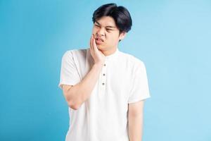 Aziatische man is boos over kiespijn tooth foto
