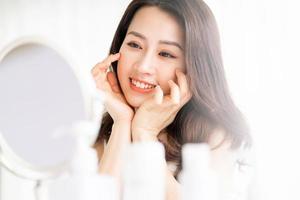 aziatische vrouw zit make-up voor spiegel foto