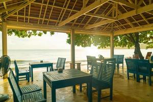 lege houten stoelen met strand zee achtergrond foto