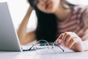 jong Aziatisch meisje moe van het lange tijd werken op de computer