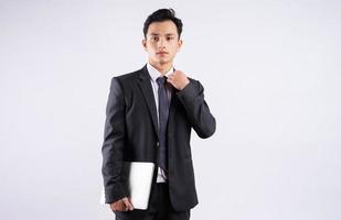 jonge Aziatische zakenman met behulp van laptop op witte achtergrond foto