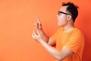 jonge aziatische man die de telefoon vasthoudt met een verbaasde uitdrukking