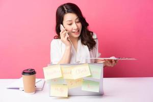 jonge Aziatische zakenvrouw zitten werken met expressie op background