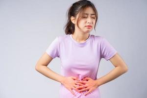 jonge Aziatische vrouw die lijdt aan gastritis foto