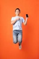 Aziatische zakenman die smartphone springt en vasthoudt holding foto