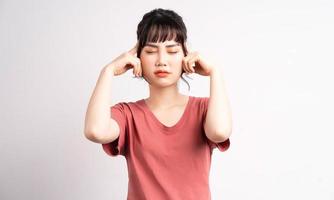 het jonge Aziatische meisje bedekte haar oren met haar handen met een geërgerde uitdrukking