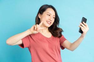 Aziatische vrouw gebruikt smartphone om selfies te maken foto