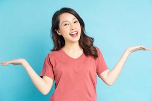 portret van een mooie aziatische vrouw die haar handen naar haar zij uitstrekt en op een vriendelijke manier glimlacht foto