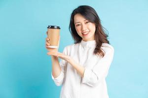 mooie Aziatische zakenvrouw met papieren koffiekopje in haar hand foto