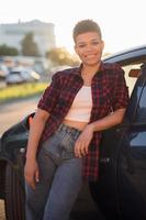 mooie Afro-Amerikaanse vrouw met kort haar in de buurt van de auto, lifestyle,
