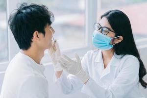 Aziatische vrouwelijke arts die de tanden van een patiënt controleert foto
