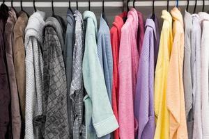 verschillende kleuren badjassen op de hanger in de doucheruimte foto