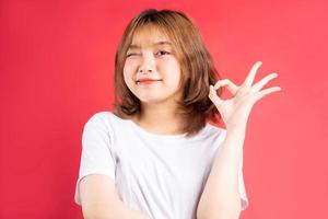 jong Aziatisch meisje met vrolijke gebaren en uitdrukkingen op achtergrond foto
