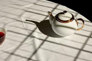 modernistisch theepot ontwerp Aan een wit tafelkleed, de theepot schaduw uitrekken lang in de moeilijk verlichting, reflecterend een hedendaags esthetisch en stoutmoedig stijl. foto