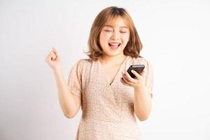 jong Aziatisch meisje met telefoon met uitdrukkingen, gebaren op de achtergrond foto