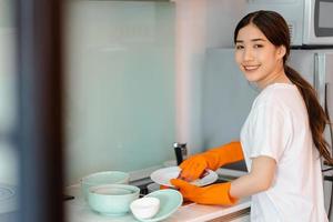 de Aziatische vrouw doet de afwas foto