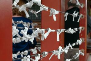 wit papier stropdas knoop in tokyo en Kyoto Japan altaar tempel toerisme wens en bidden voor geluk, symbool van geloof en fortuin geestelijk Azië Boeddhisme cultuur traditie hoop voor mooi zo kans toekomst lotsbestemming foto