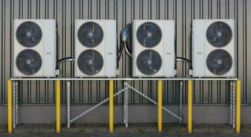 een serie van spleet lucht conditioner condensors gemonteerd Aan een gebouw muur, presentatie van modern koeling technologie. foto