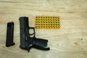 handgeweer en kogels en mags aan het liegen Aan een houten tafel foto