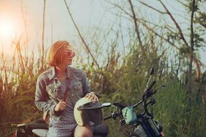 single vrouw Holding veiligheid helm zittend Aan motorfiets foto